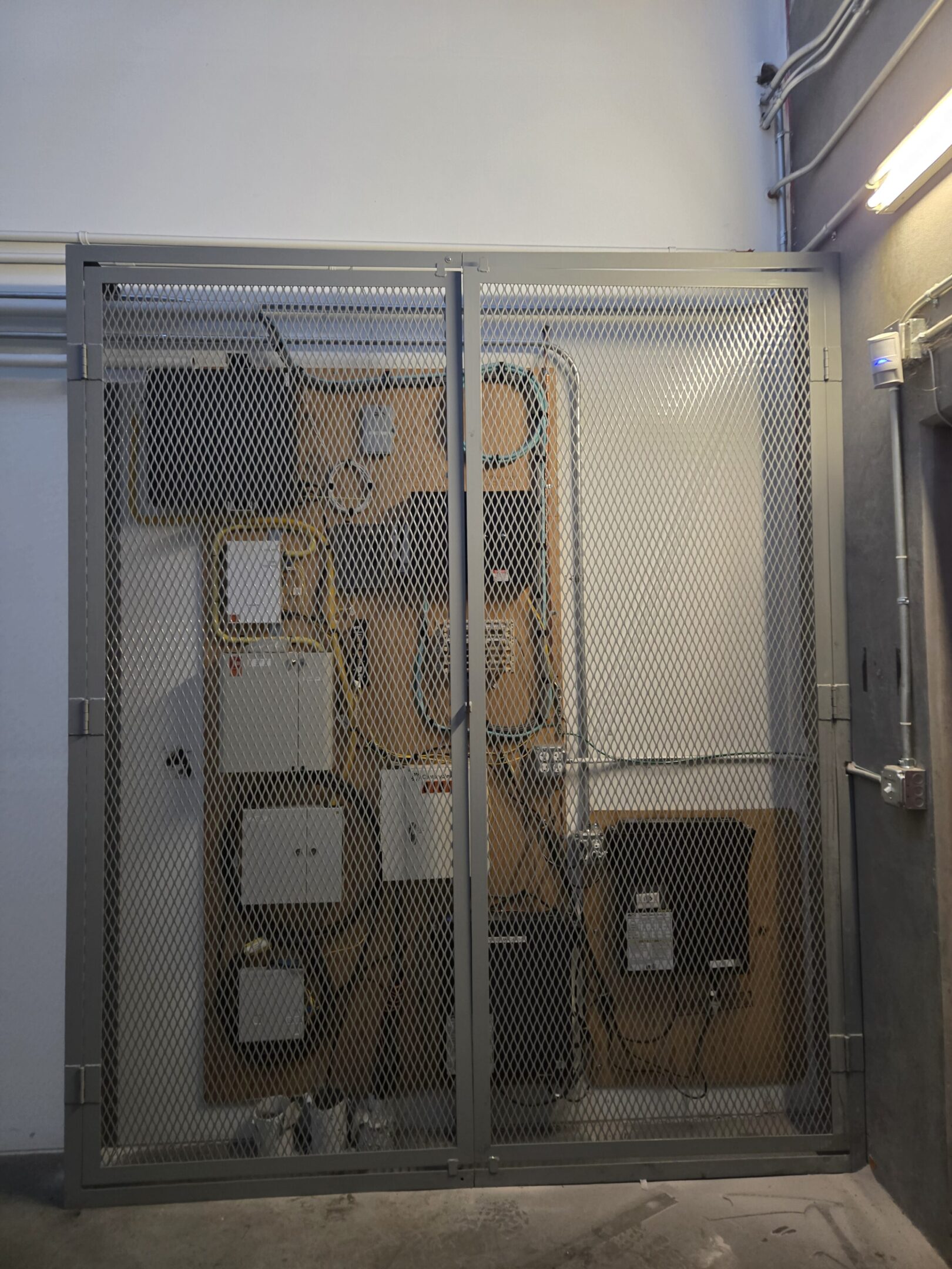 Old, damaged wall with peeling paint and exposed wiring.