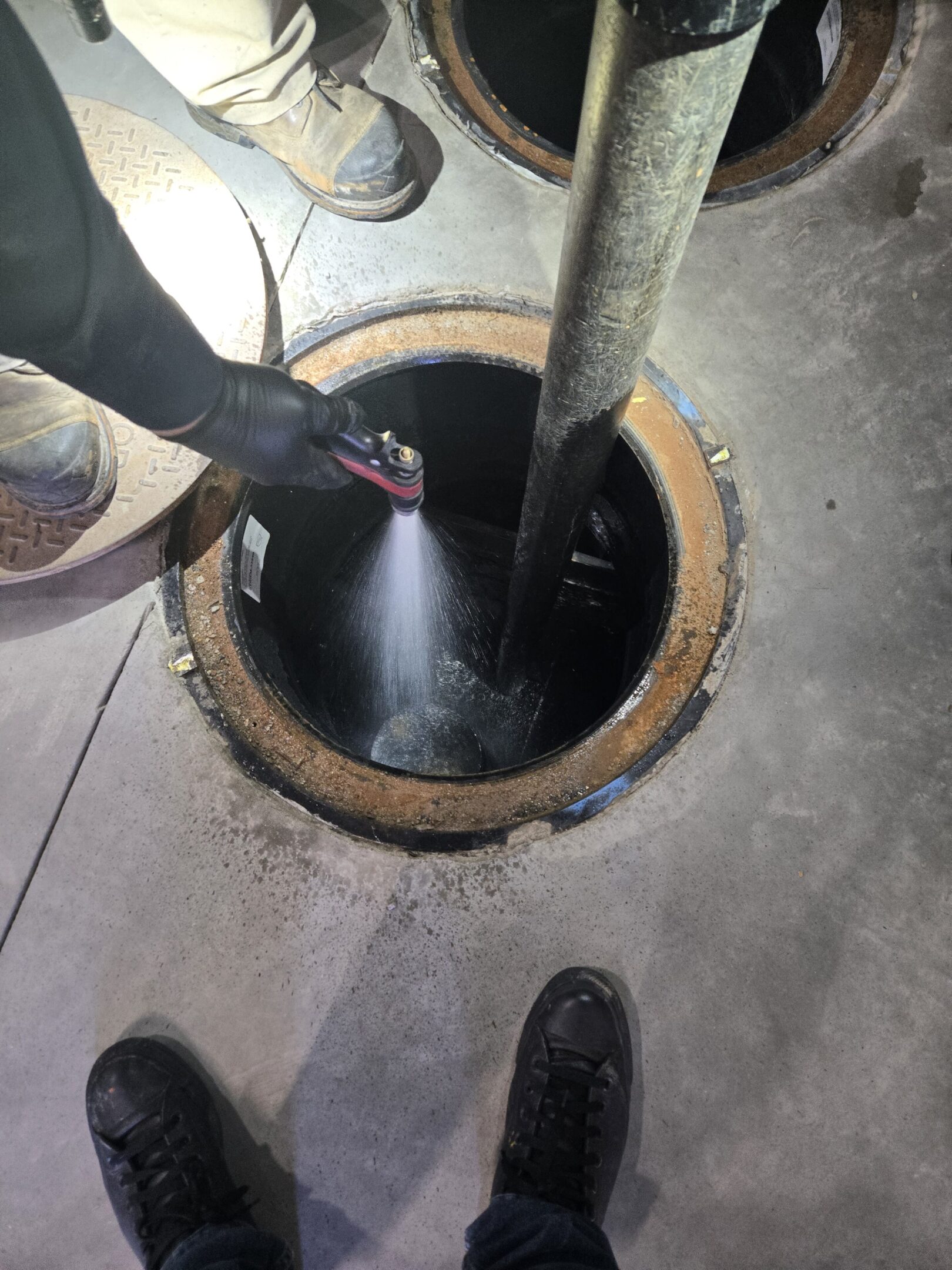 Person cleaning a sewer or drain using a hose.